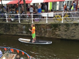 Paddleboarding through canal on Koninginnedag